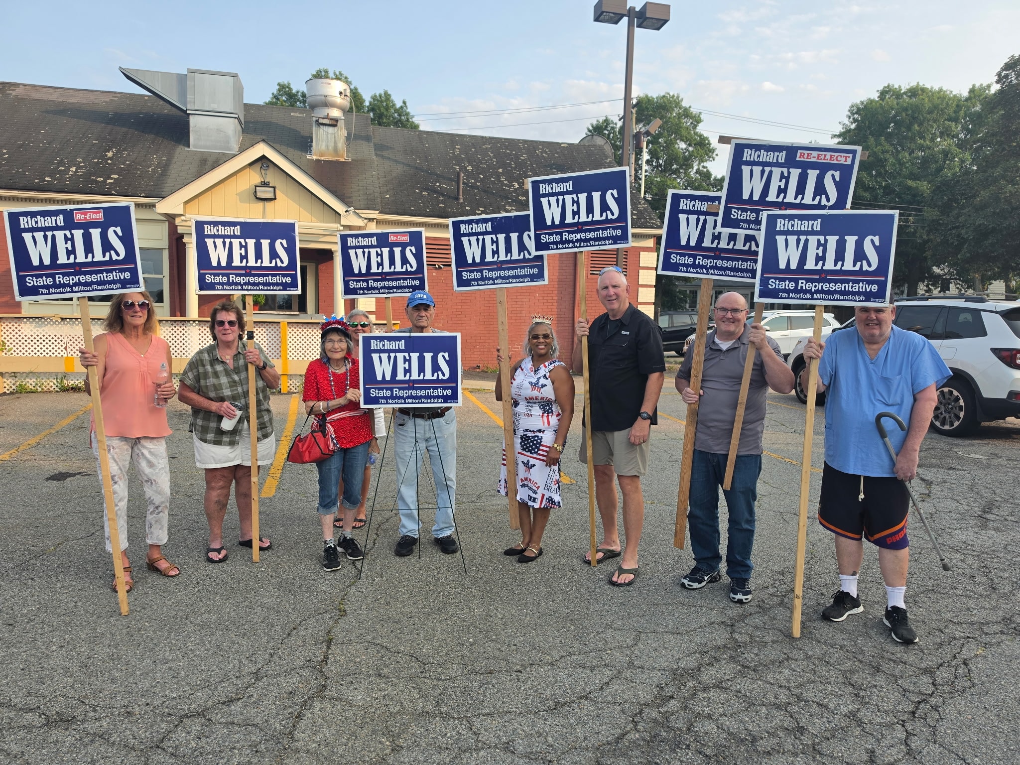 Campaign volunteers holding Richard Wells signs